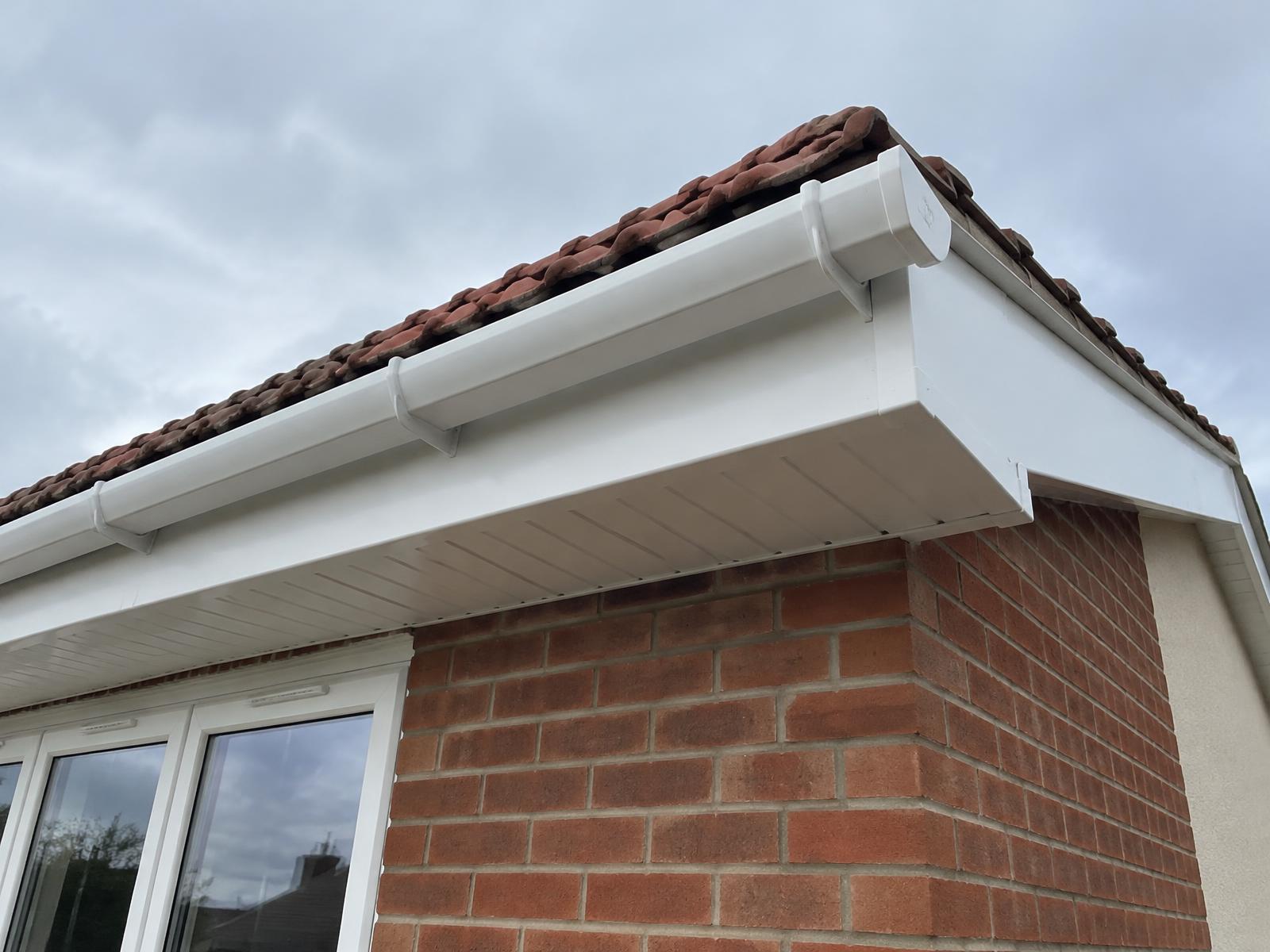 Clean white uPVC fascia, soffit and gutter on a brick house in Dorset